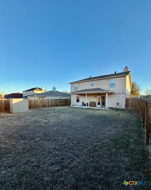 rear view of property with a patio area and a storage shed