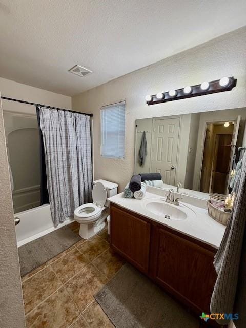 full bathroom with shower / tub combo with curtain, vanity, a textured ceiling, tile patterned floors, and toilet