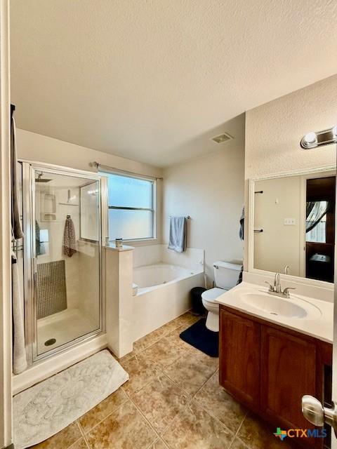 full bathroom featuring toilet, a textured ceiling, vanity, independent shower and bath, and tile patterned flooring