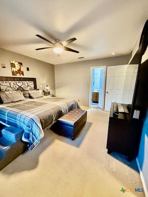 carpeted bedroom with ceiling fan and ensuite bathroom