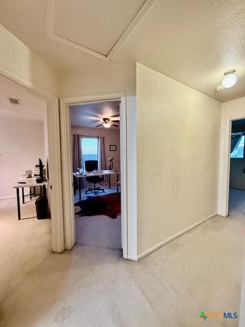 corridor featuring carpet floors and a textured ceiling