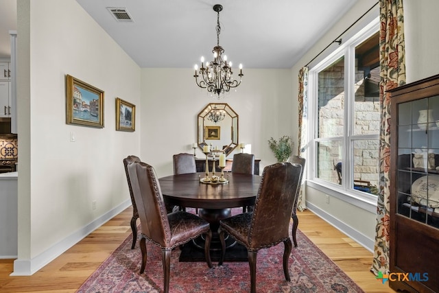 dining space featuring a chandelier and light wood-type flooring