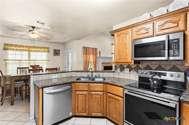 2004 Excel Dr, Killeen, TX 76542 - kitchen with stainless steel appliances, a peninsula, light tile patterned floors, and dark stone counters