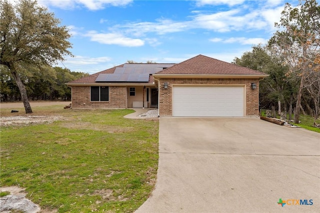 ranch-style house with a garage, a front lawn, and solar panels