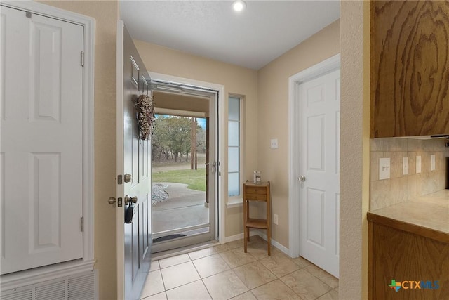 doorway with light tile patterned flooring