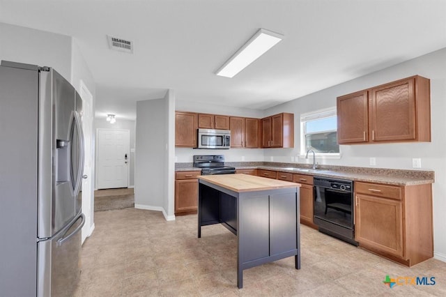 9301 Bellgrove Ct, Killeen, TX 76542 - kitchen with appliances with stainless steel finishes, a sink, brown cabinets, and baseboards