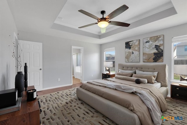 9301 Bellgrove Ct, Killeen, TX 76542 - bedroom featuring a raised ceiling, wood finished floors, ensuite bathroom, and a ceiling fan