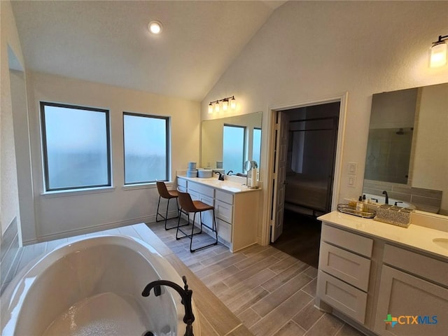 2961 Grove Way, Seguin, TX 78155 - full bathroom with lofted ceiling, a garden tub, two vanities, and wood finished floors
