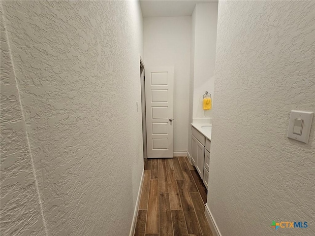 2961 Grove Way, Seguin, TX 78155 - hallway featuring a textured wall and dark wood-style flooring