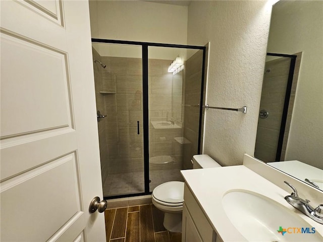2961 Grove Way, Seguin, TX 78155 - full bathroom featuring a textured wall, wood finished floors, a stall shower, and vanity