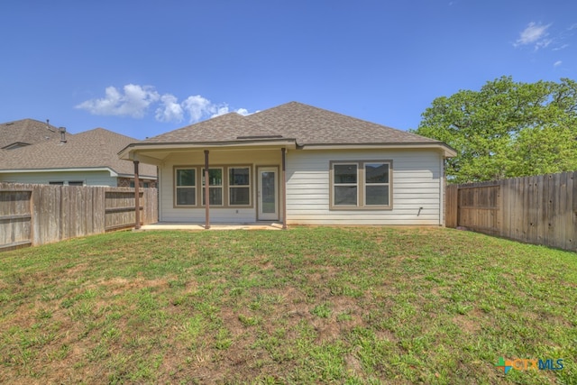 rear view of house with a patio and a yard