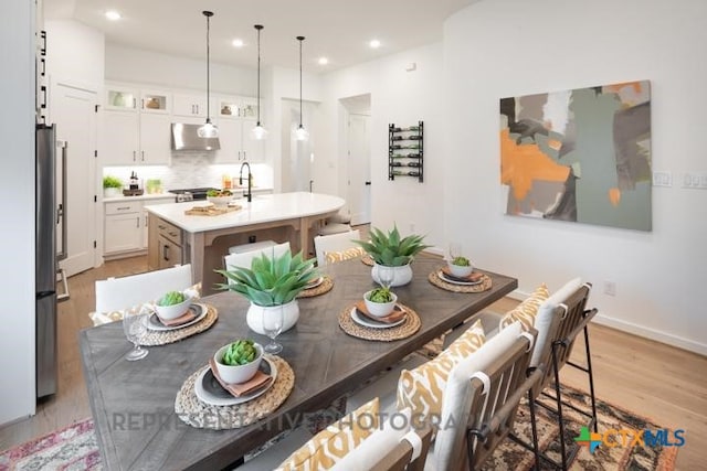 dining room featuring recessed lighting, baseboards, and light wood-type flooring