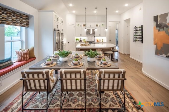 dining area featuring recessed lighting, baseboards, and light wood-type flooring