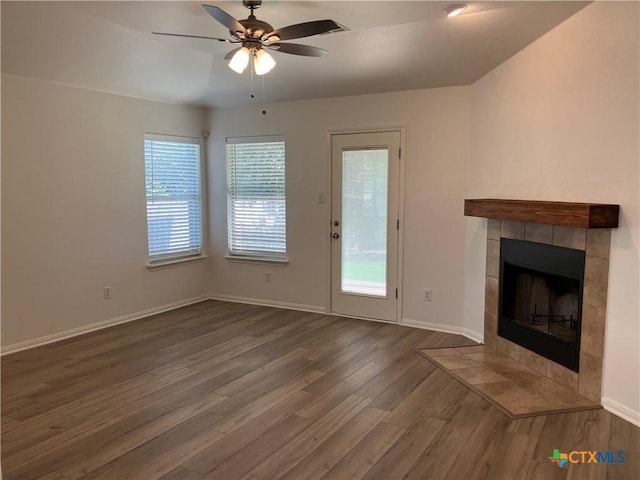 512 Constellation Dr, Killeen, TX 76542 - unfurnished living room featuring a tile fireplace, wood finished floors, a ceiling fan, and plenty of natural light