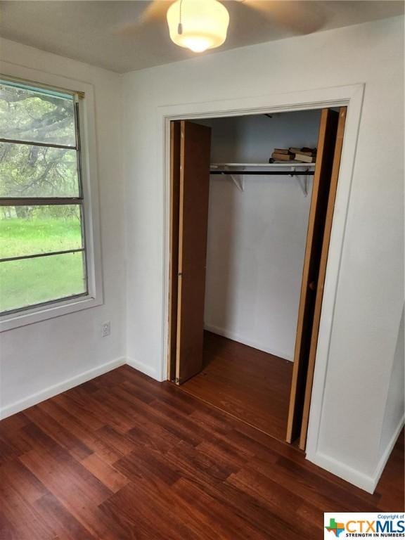 106 Beach Dr, Sunrise Beach, TX 78643 - unfurnished bedroom with a closet, dark wood finished floors, and baseboards