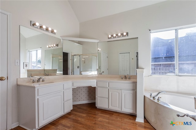 bathroom featuring hardwood / wood-style floors, a wealth of natural light, vanity, and lofted ceiling