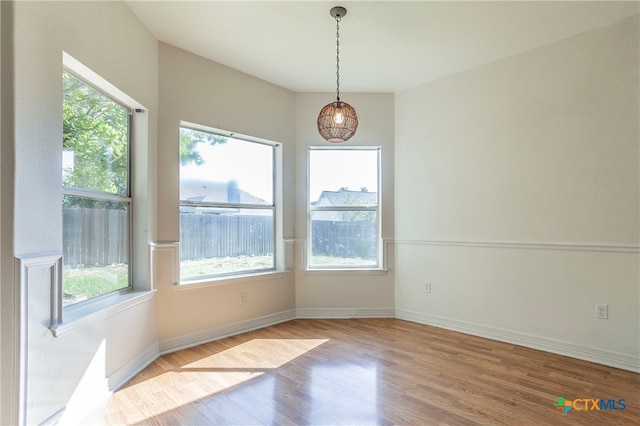 unfurnished dining area with hardwood / wood-style floors and a healthy amount of sunlight