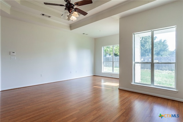 unfurnished room with wood-type flooring, ceiling fan, crown molding, and a tray ceiling