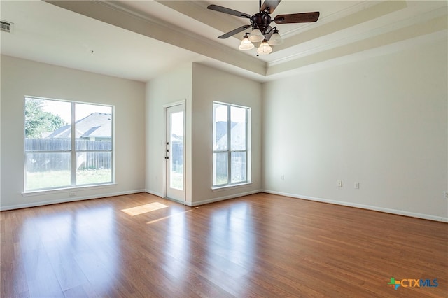 unfurnished room featuring ornamental molding, ceiling fan, a tray ceiling, and light hardwood / wood-style floors