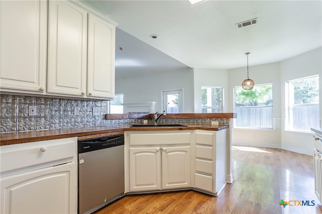 kitchen featuring stainless steel dishwasher, sink, light hardwood / wood-style floors, and white cabinets