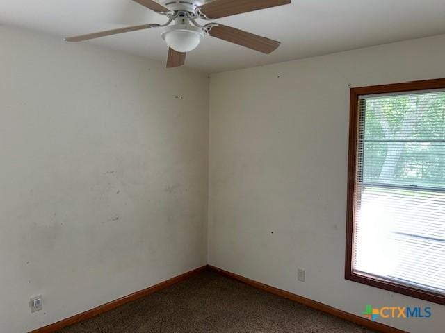 spare room featuring ceiling fan, carpet floors, a healthy amount of sunlight, and baseboards