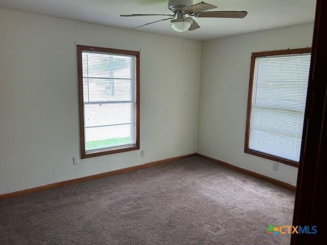 empty room featuring a ceiling fan, carpet floors, and a healthy amount of sunlight