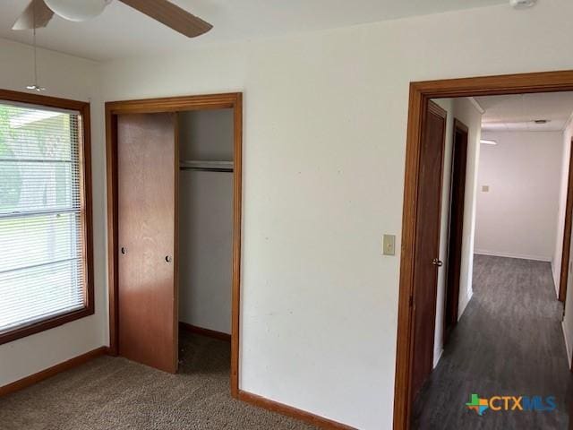 unfurnished bedroom with a closet, a ceiling fan, baseboards, and multiple windows