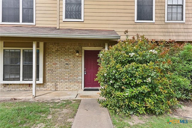 view of exterior entry with brick siding
