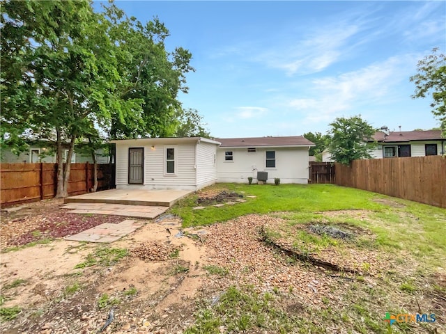 rear view of property featuring a yard and a patio