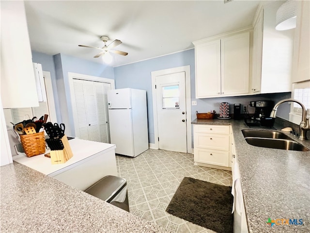 kitchen featuring white cabinetry, sink, ceiling fan, and white refrigerator