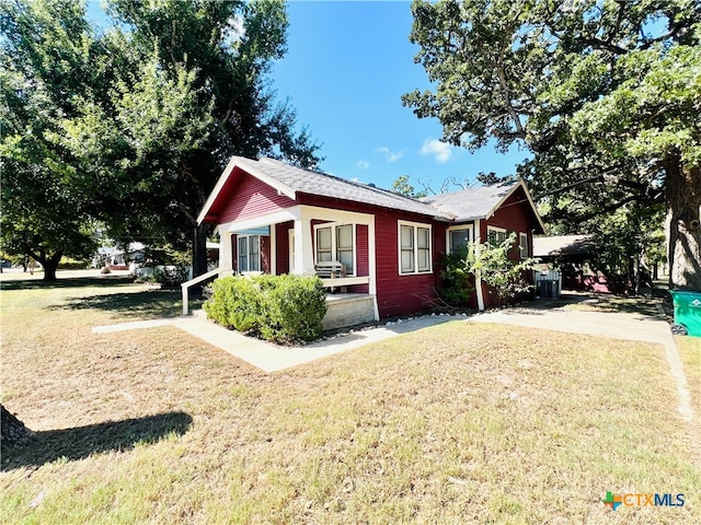 view of side of home with central AC unit and a lawn