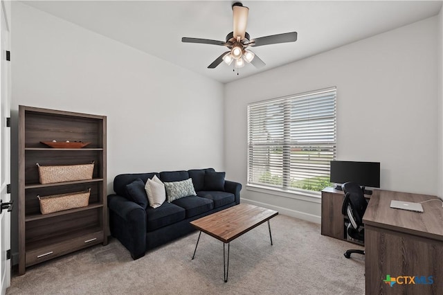 office space with light colored carpet, ceiling fan, and baseboards