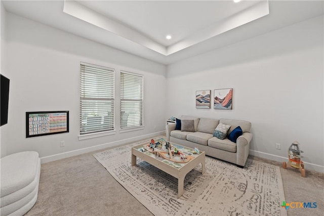 carpeted living room with baseboards, recessed lighting, and a tray ceiling