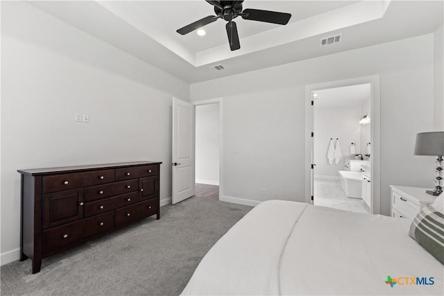 bedroom featuring a raised ceiling, visible vents, and baseboards