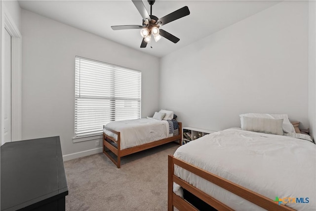 bedroom featuring ceiling fan, light colored carpet, and baseboards