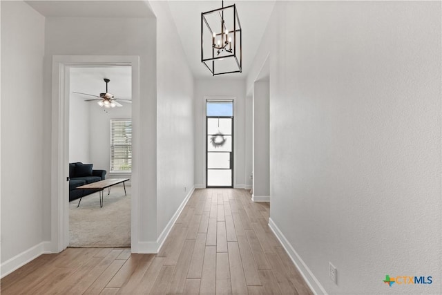 interior space featuring baseboards, light wood finished floors, and plenty of natural light