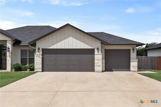 view of front of house featuring a garage, a shingled roof, and stone siding