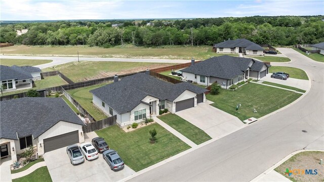 drone / aerial view with a wooded view and a residential view