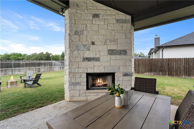 view of patio / terrace with a fenced backyard and an outdoor stone fireplace