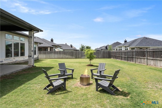 view of yard featuring an outdoor fire pit, a residential view, and a fenced backyard