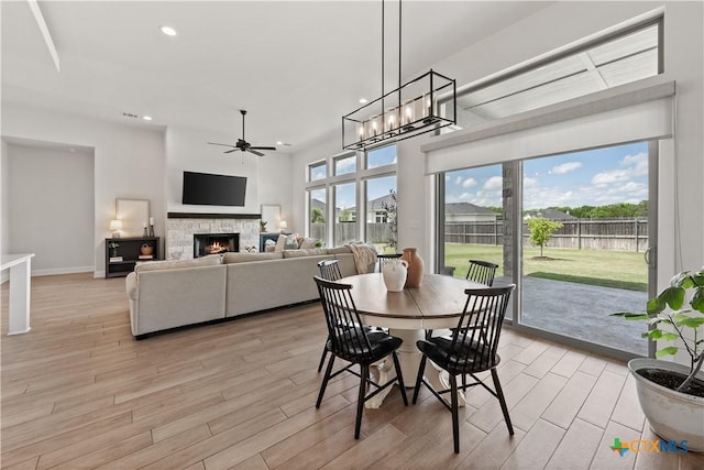 dining area with recessed lighting, light wood-style floors, ceiling fan, a fireplace, and baseboards