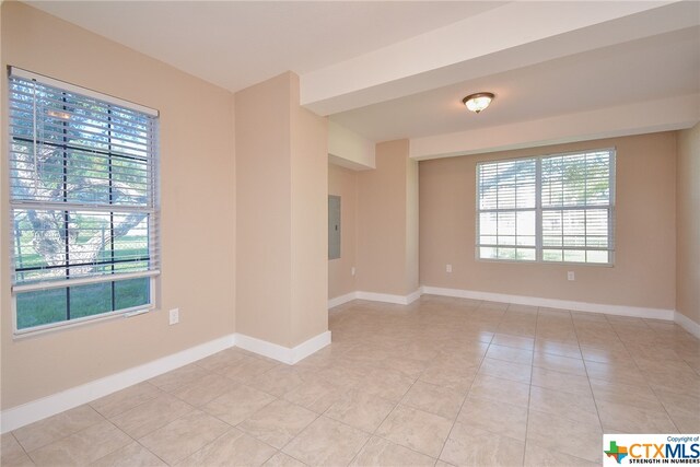 tiled spare room featuring electric panel