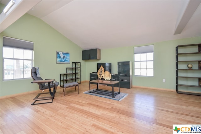 living area featuring light hardwood / wood-style floors, lofted ceiling, and a healthy amount of sunlight