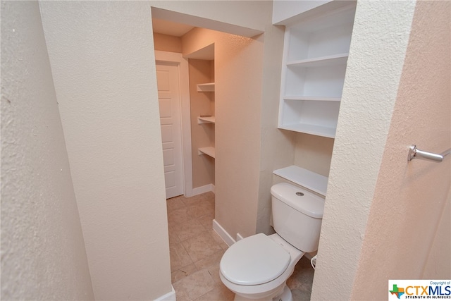 bathroom with built in features, tile patterned flooring, and toilet