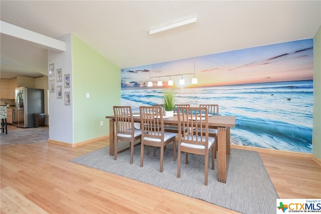 dining area with hardwood / wood-style flooring and vaulted ceiling