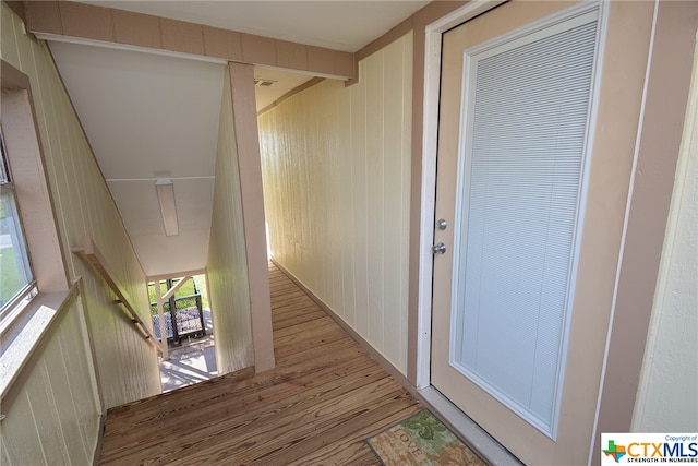 interior space with wooden walls, hardwood / wood-style floors, and a healthy amount of sunlight