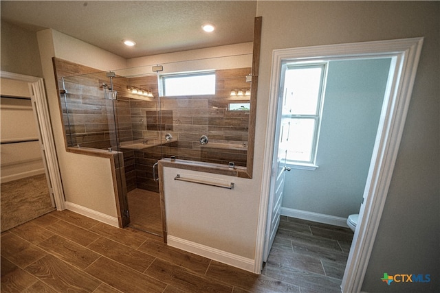 bathroom featuring toilet and a shower with shower door