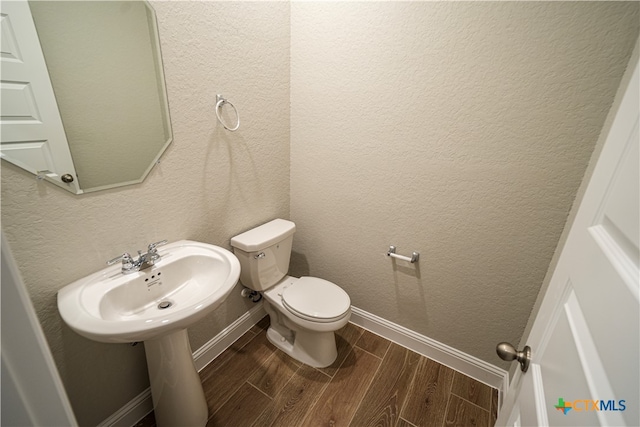 bathroom with toilet and hardwood / wood-style floors