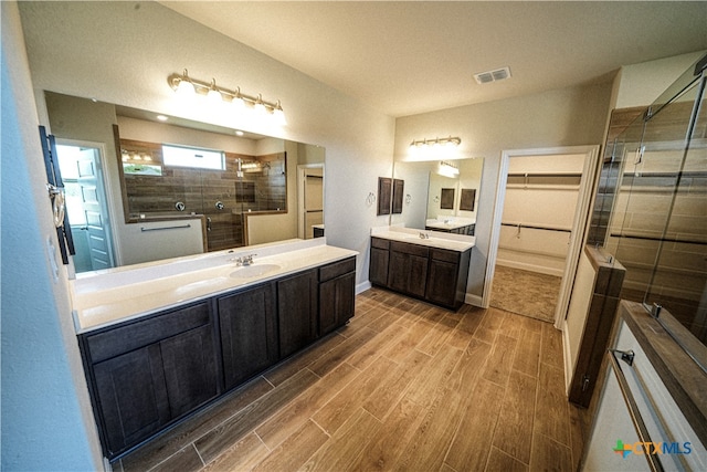 bathroom with a shower with door and vanity