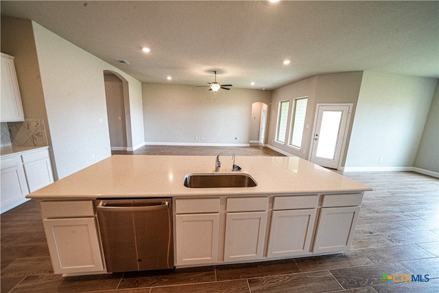 kitchen featuring a center island with sink, dishwasher, sink, backsplash, and white cabinetry